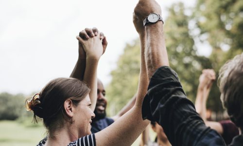 Happy diverse people holding hands in the park